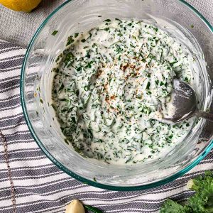 kale and garlic raita in glass mixing bowl